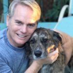 Man smiling and hugging a dog, named Molly